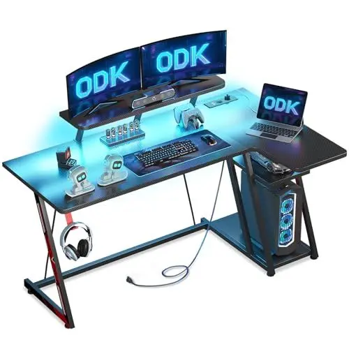 Produktbild: ODK Gaming Tisch mit LED Beleuchtung & Steckdosen, Gaming Schreibtisch L Form mit Ablagefläche, Eckschreibtisch mit Monitorständer, Computertisch PC Tisch Carbon Fiber Schwarz 140 cm