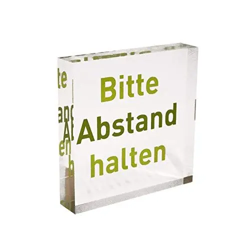 Produktbild: Transparenter Acrylblock als Infoständer/Hinweisaufsteller mit grünem Aufdruck „Bitte Abstand halten“ aus PLEXIGLAS®